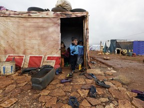 Umm Ali's children who fled the violence in the northern Syrian city of Aleppo, play at the entrance of their tent at an unofficial refugee camp in Jabaa, a village in the Bekaa Valley in Lebanon in this 2014 file photo.