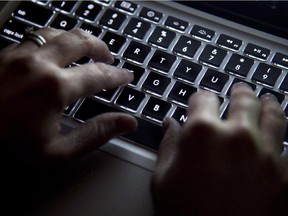 A woman uses her computer keyboard to type while surfing the internet in North Vancouver, B.C., on Wednesday, December, 19, 2012. Digital dissenters known as hacktivists have developed a track record for disruption and attracting attention and are now considered one of the three main groups of attackers online, says security software company Websense. THE CANADIAN PRESS/Jonathan Hayward ORG XMIT: CPT501