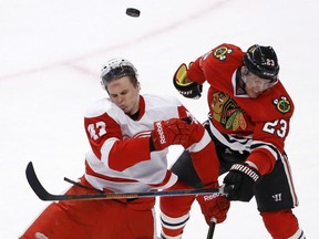 Detroit Red Wings defenseman Alexei Marchenko (47) and Chicago Blackhawks right wing Kris Versteeg collide after going for a puck in the air during the overtime period of an NHL hockey game Wednesday, Feb. 18, 2015, in Chicago. The Red Wings won in a shootout 3-2. (AP Photo/Charles Rex Arbogast)