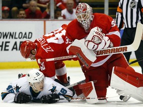 Detroit Red Wings goalie Jimmy Howard (35) stops a shot as Henrik Zetterberg (40) puts San Jose Sharks center Tomas Hertl (48) to the ice during the first period of an NHL hockey game in Detroit Thursday, March 26, 2015.  (AP Photo/Paul Sancya)