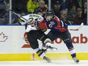 London Knights forward CJ Yakimowicz is hit by Windsor Spitfires forward Daniel Beaudoin during their OHL hockey game at Budweiser Gardens in London, Ont. on Friday October 30, 2015. Craig Glover/The London Free Press/Postmedia Network