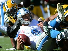 Matthew Stafford #9 of the Detroit Lions reacts after a sack by Mike Neal #96 of the Green Bay Packers on third down during the third quarter at Lambeau Field on October 6, 2013 in Green Bay, Wisconsin.  (Photo by Harry How/Getty Images) ORG XMIT: 178970697