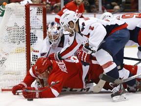 Detroit Red Wings left wing Justin Abdelkader (8) is checked to the ice by defenseman Matt Niskanen (2) after Washington Capitals goalie Braden Holtby stopped his shot in the second period of an NHL hockey game Tuesday, Nov. 10, 2015, in Detroit. (AP Photo/Paul Sancya)