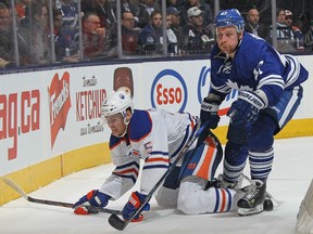 Mark Fayne #5 of the Edmonton Oilers is knocked to the ice by Leo Komarov #47 of the Toronto Maple Leafs during an NHL game at Air Canada Centre on November 30, 2015 in Toronto, Ontario, Canada. (Photo by Claus Andersen/Getty Images)