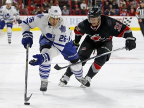 Toronto Maple Leafs' Daniel Winnik (26) advances the puck with Carolina Hurricanes' Kris Versteeg (32) in pursuit during the first period of an NHL hockey game, Friday, Nov. 20, 2015, in Raleigh, N.C. (AP Photo/Karl B DeBlaker)