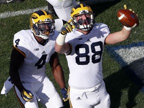 Michigan tight end Jake Butt (88) celebrates his touchdown catch with teammate De'Veon Smith (4) during the first half of an NCAA college football game against Penn State in State College, Pa., Saturday, Nov. 21, 2015. (AP Photo/Gene J. Puskar)
