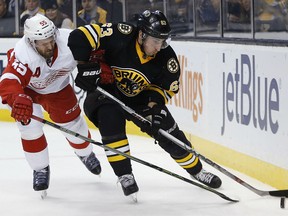 APDetroit Red Wings' Niklas Kronwall (55) and Boston Bruins' Brad Marchand (63) battle for the puck during the second period of an NHL hockey game in Boston, Saturday, Nov. 14, 2015. (AP Photo/Michael Dwyer)