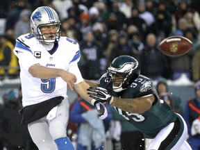 Detroit Lions' Matthew Stafford, left, passes under pressure from Philadelphia Eagles' Mychal Kendricks during the second half of an NFL football game on Sunday, Dec. 8, 2013, in Philadelphia. (AP Photo/Matt Rourke)