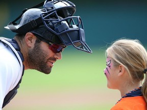 Alex Avila #13 of the Detroit Tigers greets a young Tigers fan on the field during Kids Take the Bases prior to the start of the game against the Cleveland Indians at Comerica Park on September 14, 2014 in Detroit, Michigan.  (Photo by Leon Halip/Getty Images)