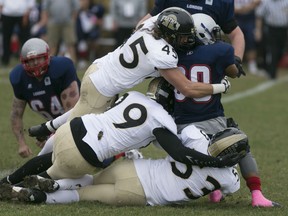 The AKO defence, top to bottom, Darren Quennell, Adam Slikboer, and Adam Chin tackle London's John Arbeledo during Ontario Football Conference action between the AKO Fratmen and the visiting London Beefeaters at E.J. Lajeunesse, Saturday, Oct. 24, 2015.  (DAX MELMER/The Windsor Star)