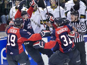 Arms raised, Logan Brown and his Windsor Spitfire terammates celebrate in front to the London Knights bench after Brown's overtime goal game his team a 6-5 win at Budweiser Gardens in London, Ont. on Saturday October 3, 2015.  Derek Ruttan/The London Free Press/Postmedia Network