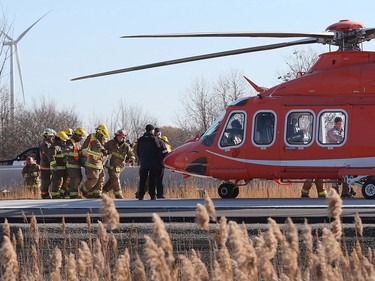Firefighters transport a victim to an Ornge Air Ambulance on Highway 401 following an accident in the eastbound lanes near Tilbury, Ont. on Nov. 25, 2015.