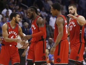 Toronto Raptors' Cory Joseph, DeMarre Carroll, DeMar DeRozan and Jonas Valanciunas, fromleft, celebrate as they walk off the court during a timeout in the fourth quarter of an NBA basketball game against the Oklahoma City Thunder in Oklahoma City, Wednesday, Nov. 4, 2015. Toronto won 103-98. (AP Photo/Sue Ogrocki)