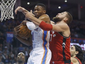Oklahoma City Thunder guard Russell Westbrook (0) grabs a rebound in front of Toronto Raptors center Jonas Valanciunas during the first quarter of an NBA basketball game in Oklahoma City, Wednesday, Nov. 4, 2015. (AP Photo/Sue Ogrocki)
