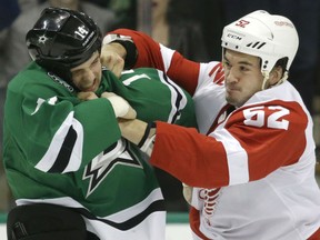 Detroit Red WIngs Jonathan Ericsson (52) and Dallas Stars left wing Jamie Benn (14) fight during the first period of an NHL hockey game Saturday, Feb. 21, 2015, in Dallas. (AP Photo/LM Otero)