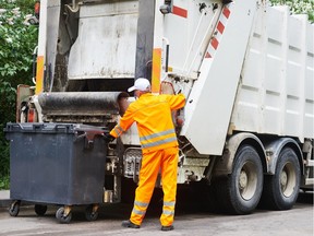 A municipal worker operates a  recycling garbage truck. (Fotolia.com)