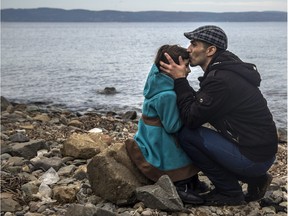 A Syrian man kisses his daughter shortly after disembarking from a dinghy at a beach on the Greek island of Lesbos after crossing the Aegean sea from the Turkish coast, Nov. 16, 2015.
