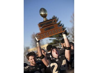 AKO defensive back, Mike Champ, hoists the championship trophy into the air after the AKO Fratmen defeated the Ottawa Sooners 21-11 in the Ontario Football Conference championship game at E.J. Lajeunesse, Sunday, Nov. 1, 2015.  (DAX MELMER/The Windsor Star)