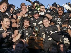 The AKO Fratmen pose with the championship trophy after defeating the Ottawa Sooners 21-11 in the Ontario Football Conference championship game at E.J. Lajeunesse, Sunday, Nov. 1, 2015.