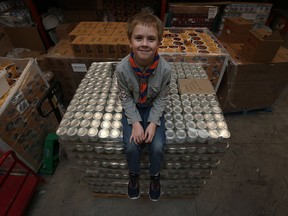 Daniel Whitehead sits on top of a load of cans at the Unemployed Help Centre in Windsor on Thursday, Nov. 26, 2015. The 10 year-old Wolf Cub is responsible for getting Bonduelle Canada Inc. to donate 2,040 cans of peas. Whitehead was taking part in a can drive at his school when he came up with the idea.