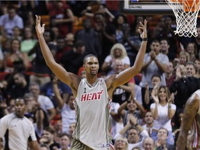 Miami Heat forward Chris Bosh (1) reacts to applause after scoring a three-point shot against the Toronto Raptors in the second half of an NBA basketball game, Sunday, Nov. 8, 2015, in Miami.