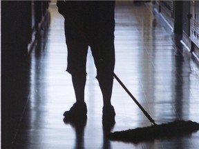 A janitor cleans a hall with a mop.
