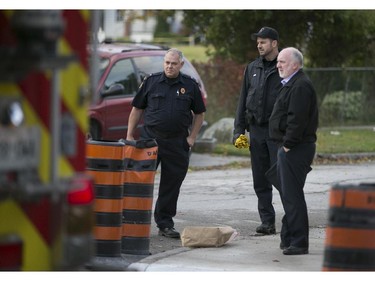 Windsor police and a member of Windsor Fire and Rescue, left, work at the scene of a pedestrian struck by a car at the intersection of Pillette Rd. and Ontario St., Sunday, Nov. 1, 2015.  They are treating the incident as an attempted murder.  (DAX MELMER/The Windsor Star)