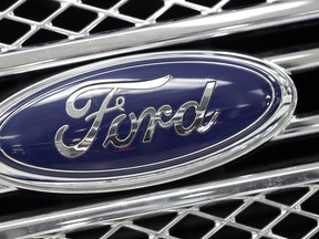 A Ford logo shines on the front grille of a 2014 Ford F-150.