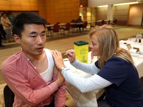 University of Windsor student Hai Qing Zhang, 38, receives a flu shot from WECHU registered nurse Virginia Myers during a clinic at the University of Windsor on Nov. 16, 2015.