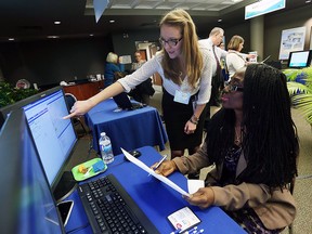 Jovana Burz gives Justina Nwaeser (right) a tour the 311 system during an GIS open house session at 400 City Hall Square in Windsor on Wednesday, Nov. 18, 2015.