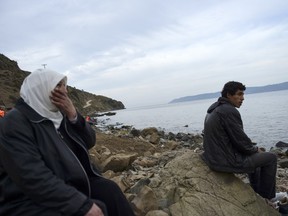 Syrian refugees take a rest just after their arrival on the Greek island of Lesbos after crossing the Aegean Sea from Turkey on November 16, 2015.