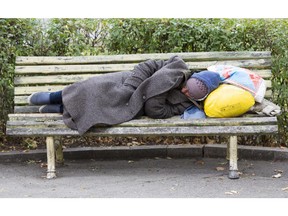 Homeless man sleeping on a bench. Photo by fotolia.com.