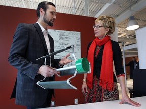 MPP Daiene Vernile speaks with Kyle Bassett of RMRD technologies during a media conference on Friday, November 13, 2015, at the University of Windsor EPICentre. She spoke about the province's $27-million investment in young innovators. Bassett, a PhD student at the school was demonstrating the micro wind turbine he designed.