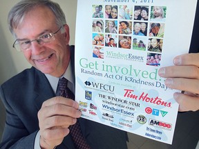 Glenn Stresman, executive director of the Windsor Essex Community Foundation, holds a Random Act of Kindness Day poster in this file photo.