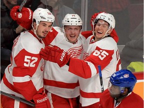 Detroit Red Wings Jonathan Ericsson, left,  Gustav Nyquist and Danny DeKeyser celebrate Nyquist's game winning goal in overtime of National Hockey League game in Montreal on  Wednesday, Feb. 26, 2014.