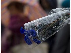 Raindrops sit on a bouquet of flowers at a temporary memorial near the Bataclan concert hall, in Paris, Tuesday, Nov. 17, 2015. France invoked a never-before-used European Union "mutual-defense clause" to demand Tuesday that its partners provide support for its operations against the Islamic State group in Syria and Iraq and other security missions in the wake of the Paris attacks.