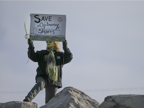 A woman holds a sign 'Save Ojibway Shores' while at the Windsor People's Climate March at the riverfront, Sunday, Nov. 29, 2015.