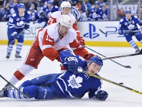 Toronto Maple Leafs' defenceman Morgan Rielly (44) gets taken down by Detroit Red Wings' forward Riley Sheahan (15) during second period NHL hockey action, in Toronto, on Nov. 6, 2015.