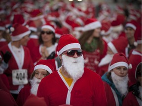 Hundreds of runners dressed up in Santa suits take part in the Super Santa 5k Run or Walk in Amherstburg, Saturday, Nov. 14, 2015.
