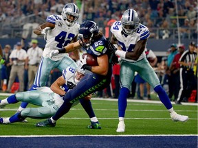 LaSalle's Luke Willson (82) of the Seattle Seahawks takes the ball across the goal line to score a touchdown against Barry Church (42), Jeff Heath (38) and Morris Claiborne (24) of the Dallas Cowboys in the second quarter at AT&T Stadium on November 1, 2015 in Arlington, Texas.