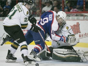 Windsor's  Christian Fischer is checked into London goalie Tyler Parsons while London's Chandler Yakimowicz attempts to clear the puck during OHL action between the Windsor Spitfires and the London Knights at the WFCU Centre, Sunday, Nov. 29, 2015.