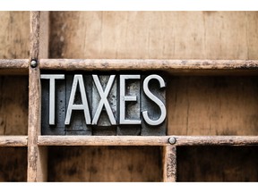 The word "TAXES" written in vintage metal letterpress type in a wooden drawer with dividers. Photo by fotolia.com.
