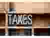 The word "TAXES" written in vintage metal letterpress type in a wooden drawer with dividers. Photo by fotolia.com.