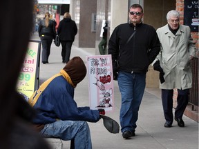 WINDSOR, ON. FEB.15, 2013  Ouellette Avenue panhandlers known as Sign Man, asks for donations as Mike Holdsworth, centre, president of Downtown Residents Association tours the area Friday February 15, 2013.  (NICK BRANCACCIO/The Windsor Star). ORG XMIT: 00018582A