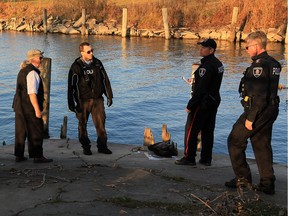 Windsor police investigate on the Detroit River at Lauzon Road where a body was discovered Wednesday November 11, 2015. Coroner Dr. Marven Oxley, left, arrived on the scene to assist with the case.