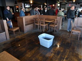 A large container holding rain water from a leaky roof sits in the middle of Abars Tavern on Riverside Drive East at Lauzon Road Friday November 13, 2015.