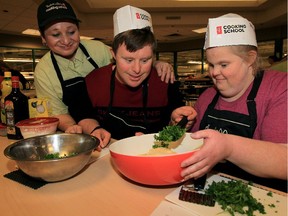 Cooking school co-ordinator Christine Watton, left, happily assists Matt Tolmie and Tiffany Todd during a cooking session at Zehr's on Lauzon Parkway November 2, 2015. Todd and Tolmie were adding fresh parsley to their garlic aioli sauce recipe.