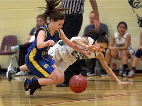 Lajeunesse point guard Diana Gharib and Rainy River's Kendra Moen go airborne while battling for the ball during OFSAA girls basketball action in Windsor, Ont., on Nov. 26, 2015. Lajeunesse won the game 53-32.