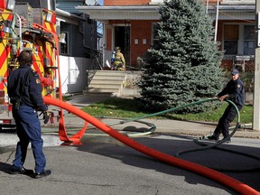 Windsor firefighters stretch lines at the scene of a fire inside a multi-unit home at 520 Church Street Nov. 30, 2015.