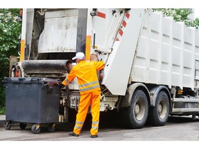 Worker of urban municipal recycling garbage collector truck loading waste and trash bin. Photo by fotolia.com.